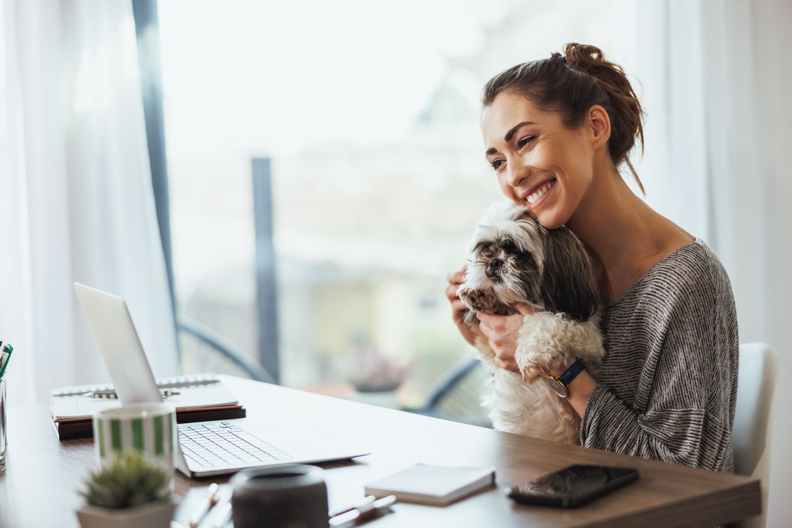 Woman on a telehealth video call with her dog on her lap